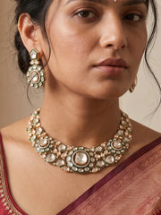 Green Kundan Polki necklace set featuring intricate stonework, green accents, antique gold-tone detailing and matching drop earrings.
