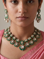 Green Kundan necklace set featuring floral motifs and teardrop-shaped stones, with matching earrings and a maang tikka in a Victorian finish.