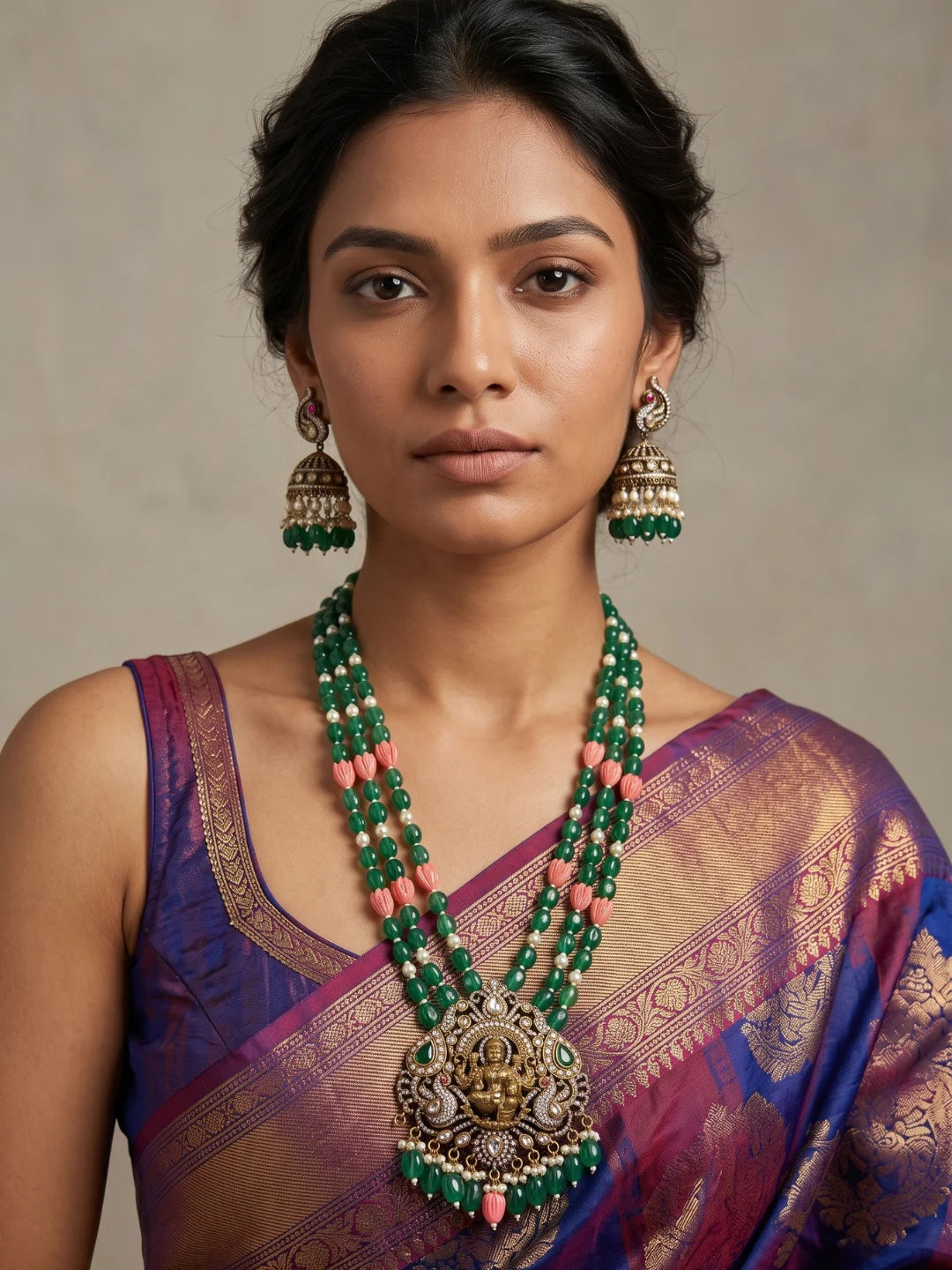Green Lakshmi temple necklace featuring an ornate Goddess pendant, antique-style detailing, layered jade beads and matching jhumka earrings.