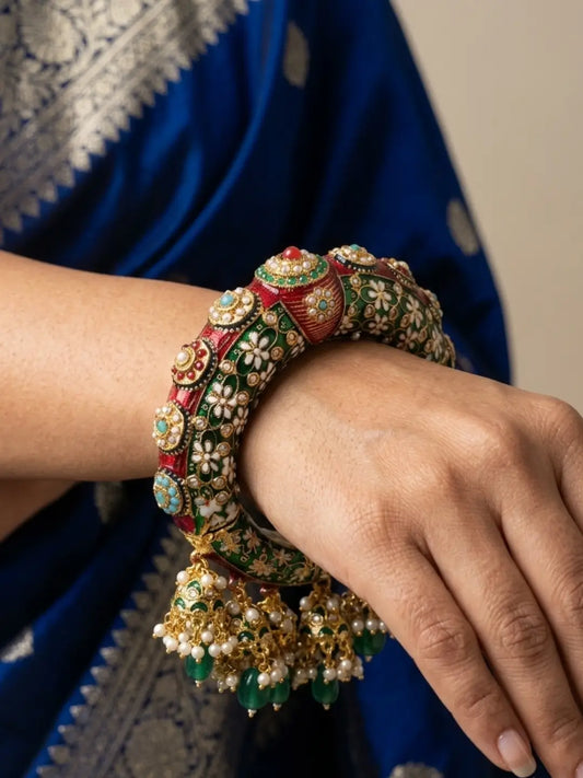 Green Meenakari Kundan kada bangle with jhumka drops, pearl details and stone accents, designed for bridal, wedding and festive outfits.