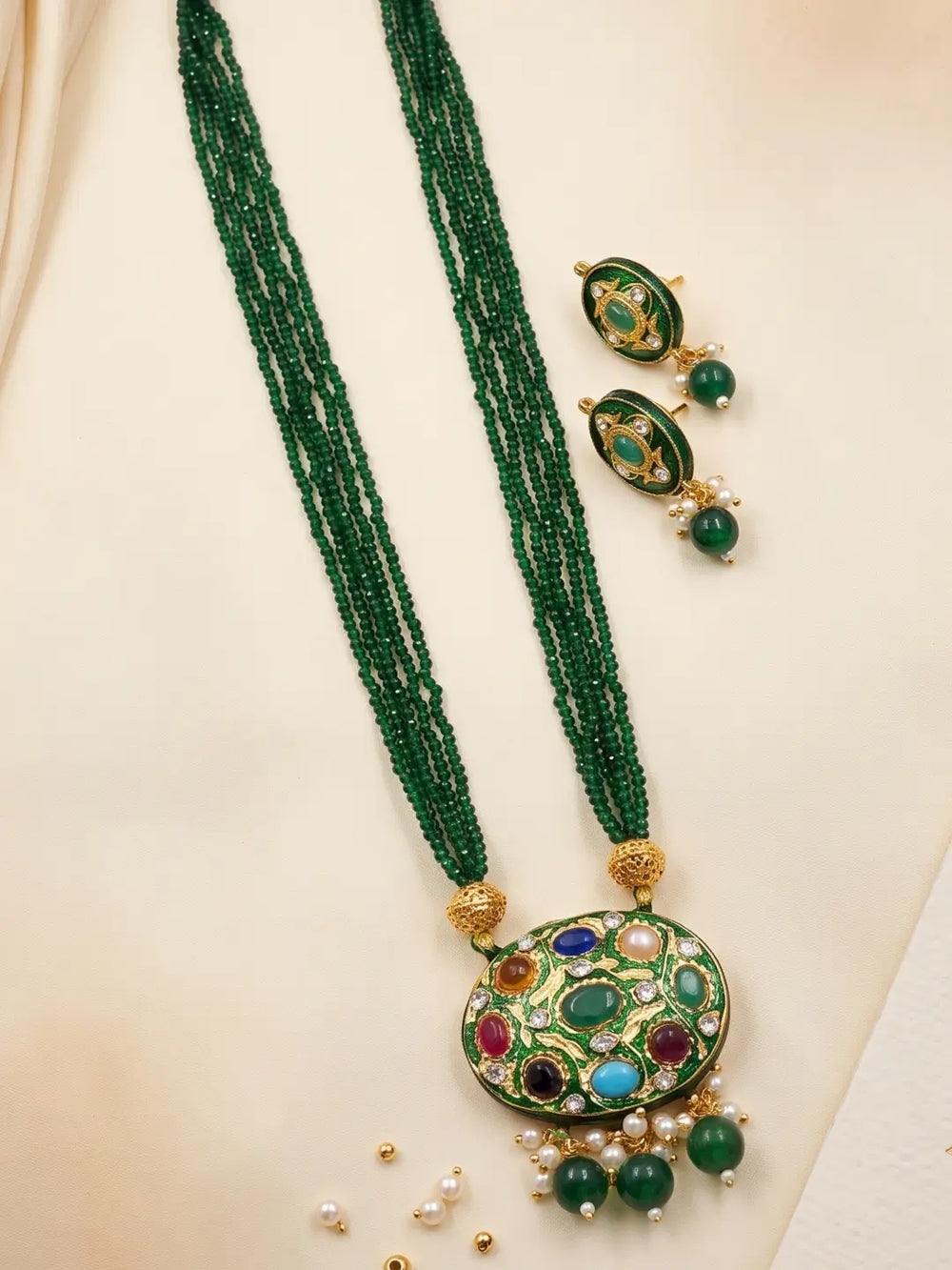 Green layered bead necklace with a Navratna Meenakari pendant, pearl accents and matching stud earrings in a traditional design.