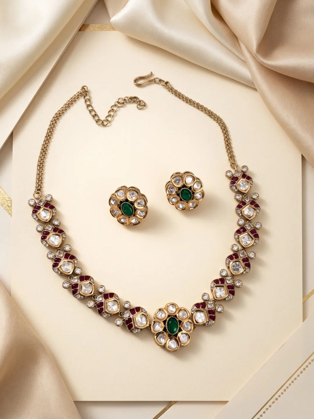 Green Polki necklace set with a decorative floral centre, dual-tone plating, coloured accents and matching statement studs.