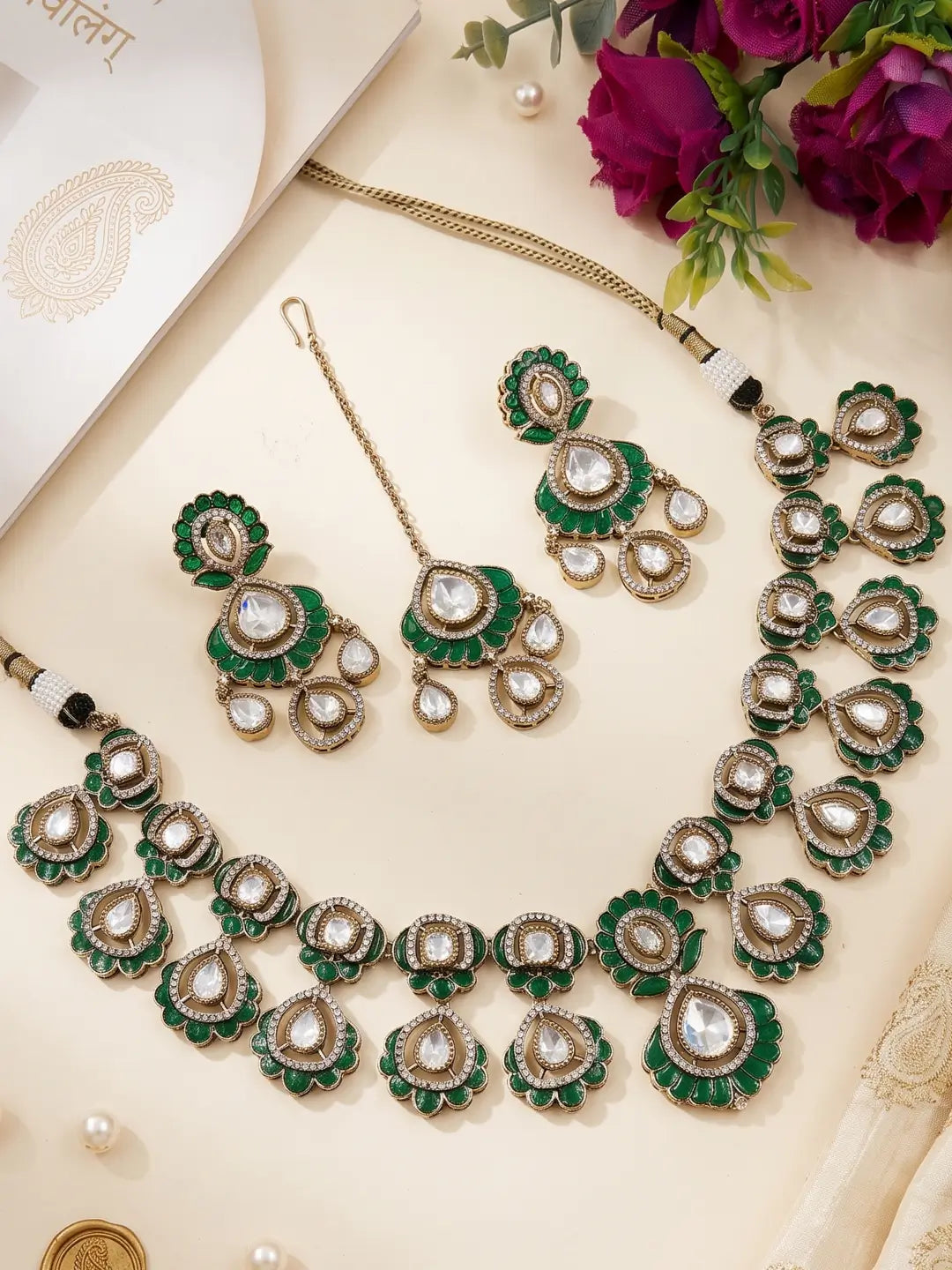 The necklace combines a green and Victorian-finish look with repeating floral-inspired motifs, teardrop-shaped stones, and detailed green accents.