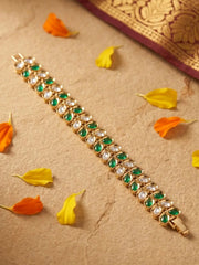 Decorative bracelet with green and white polki stones on a beige background with floral petals.