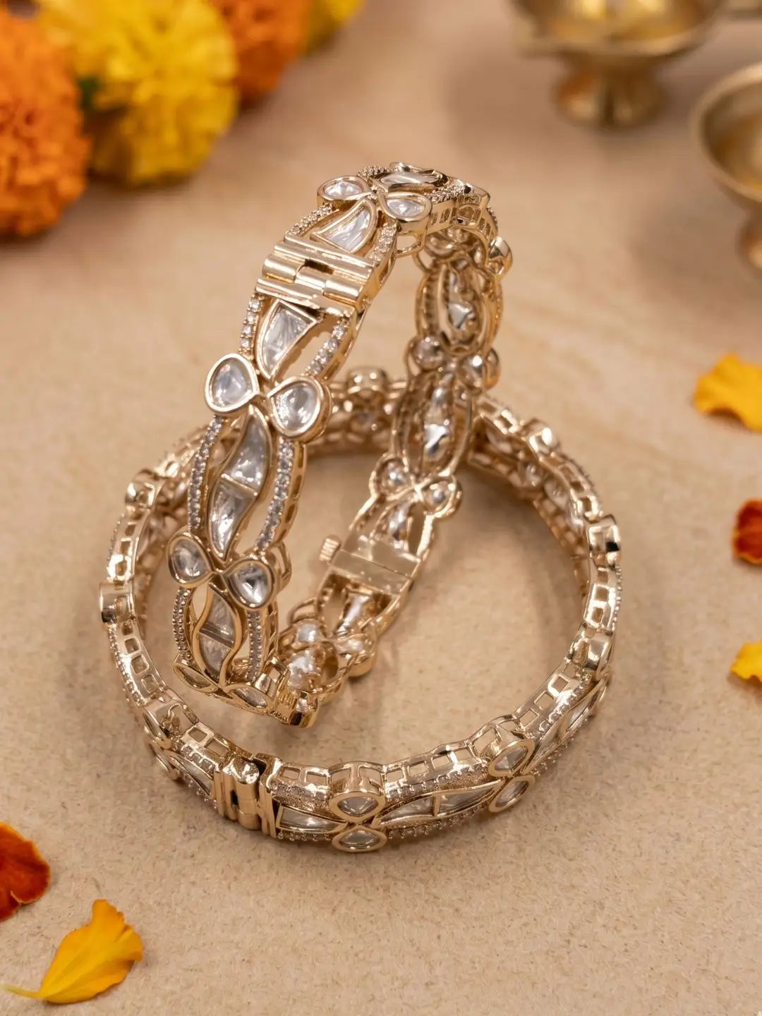 EThnic gold-plated kundan polki bangles with intricate designs on a beige background with flowers.