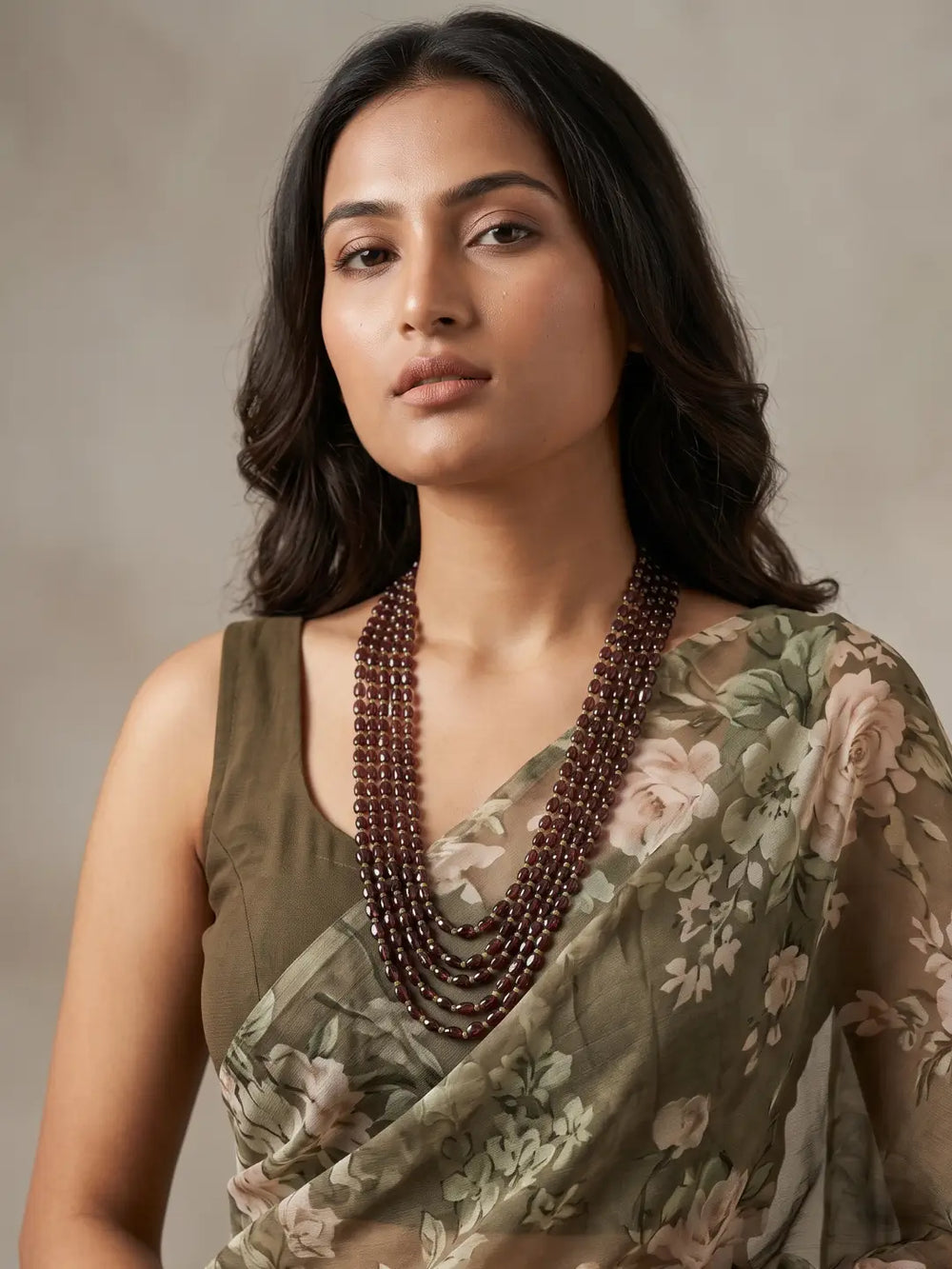 Layered garnet beaded necklace showing the gold-plated detailing and the adjustable hook-and-eye closure at the back for a comfortable fit