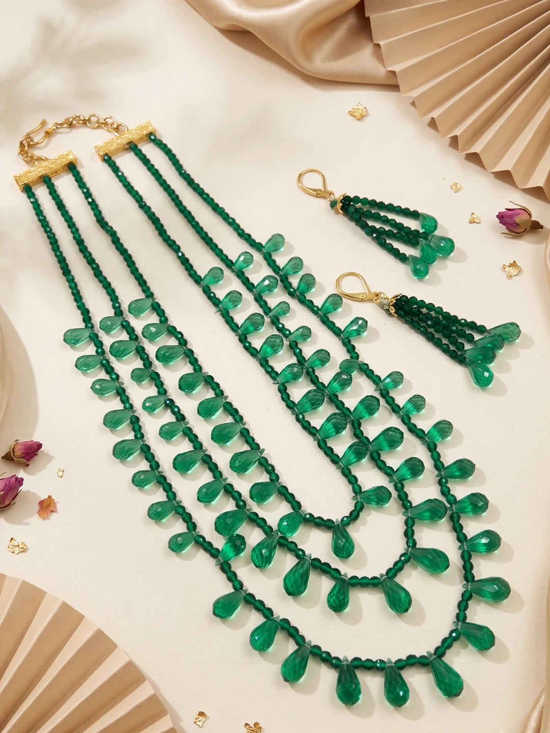 Back view of a layered green beaded necklace showing the adjustable hook-and-eye closure and the strands falling evenly around the neckline