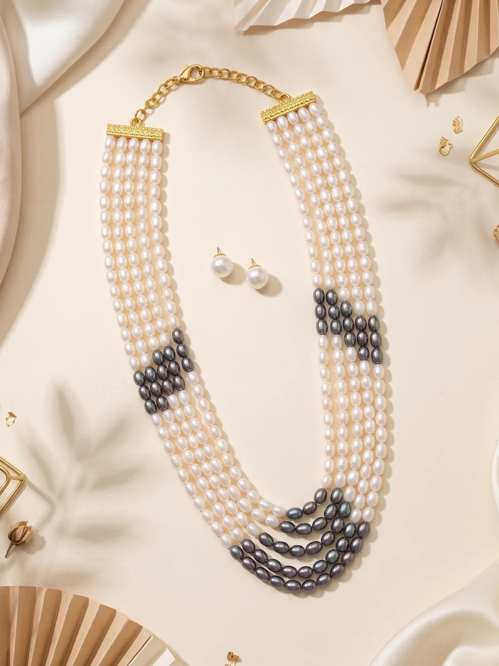 Multi-strand grey and white pearl necklace showing its adjustable hook-and-eye closure and the curved layers sitting around the neckline