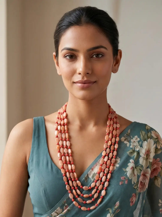 Layered red coral and natural moonstone beaded mala with gold plating, featuring multiple strands for wedding and festive ethnic styling.
