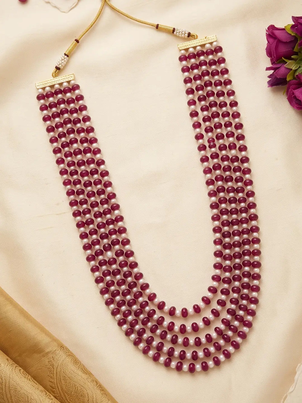 Layered ruby red jade and natural freshwater pearl mala with a long multi-strand design and gold-plated details for festive and wedding occasions.