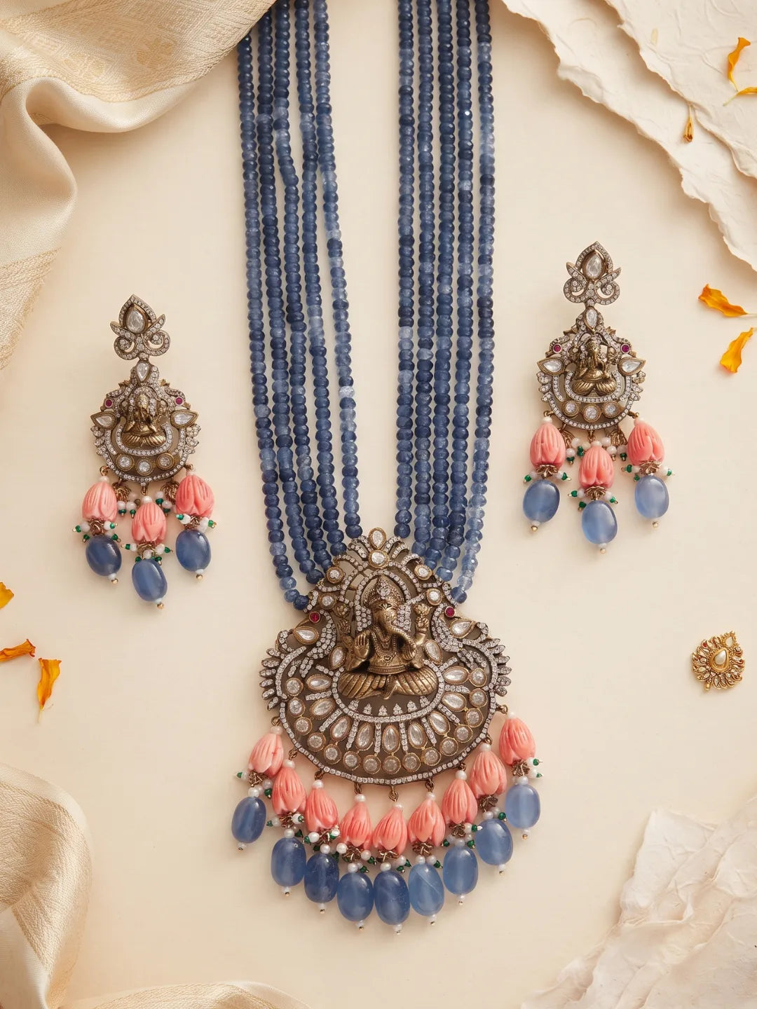 Traditional blue temple jewellery featuring a detailed Ganesha pendant, Kundan and Polki stone accents, multistrand beads and matching earrings.