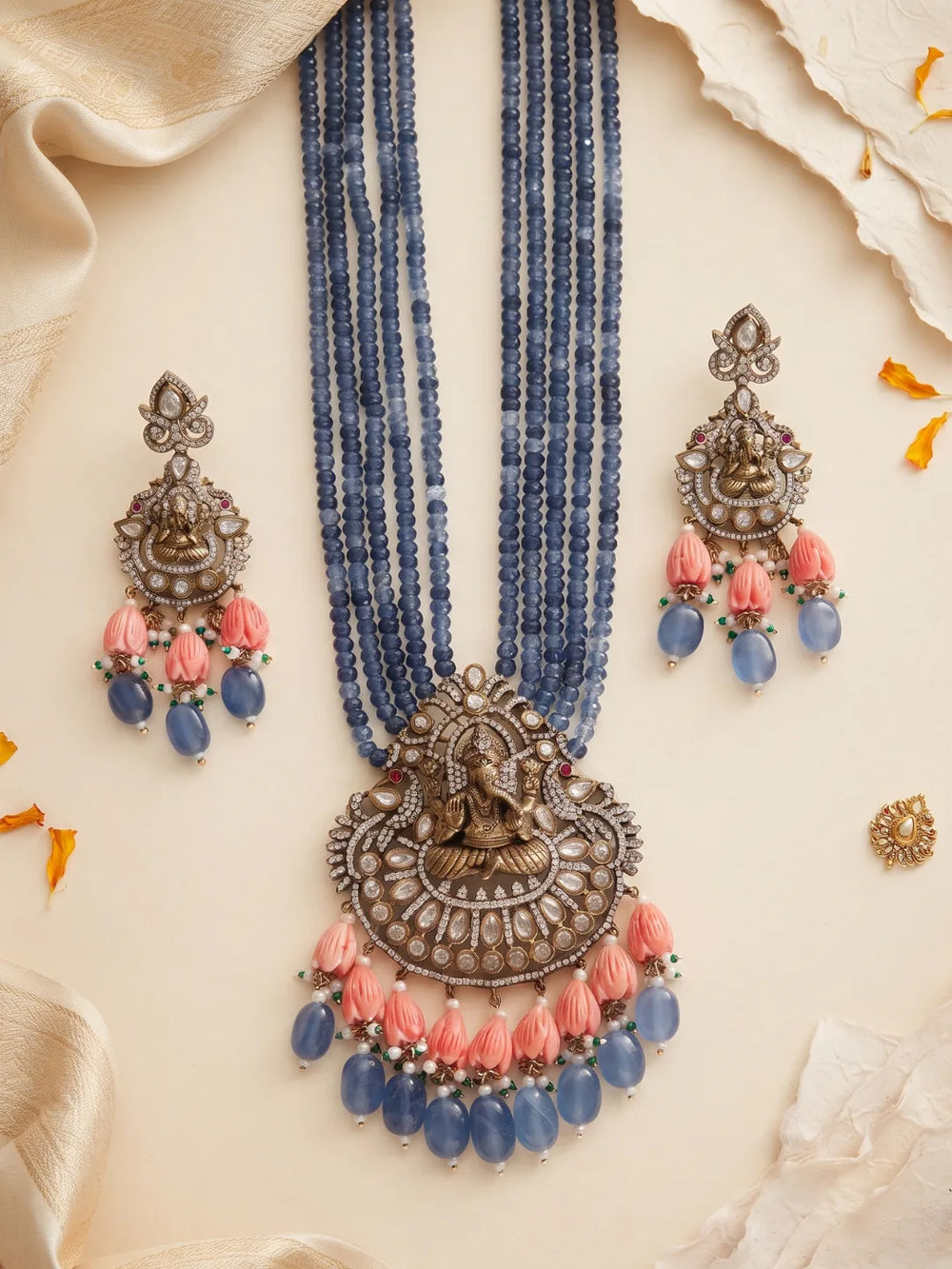 Traditional blue temple jewellery featuring a detailed Ganesha pendant, Kundan and Polki stone accents, multistrand beads and matching earrings.
