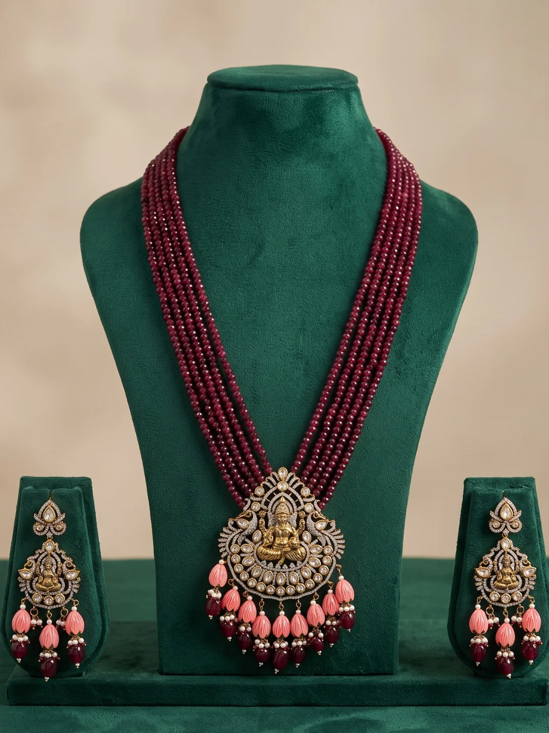 Traditional maroon temple jewellery featuring a detailed Ganesha pendant, Kundan and Polki stone accents, multistrand beads and matching earrings.