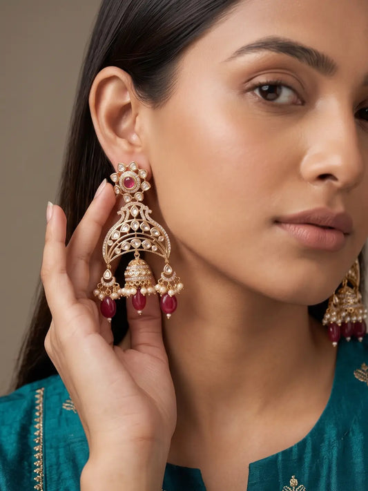 Long red Kundan Jhumka earrings with Polki and AD stone detailing, faux pearl drops and gold-plated traditional craftsmanship.
