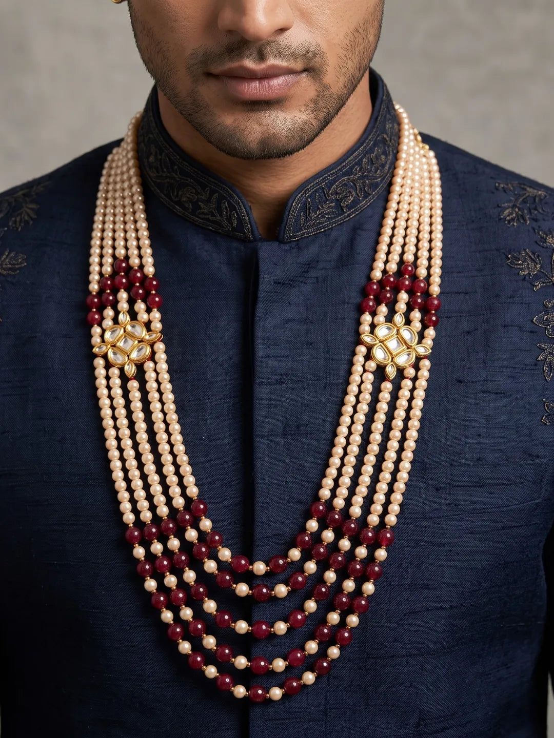 Maroon groom sherwani mala featuring multiple strands of jade beads and faux pearls, connected by ornate gold-plated Kundan-style brooches.