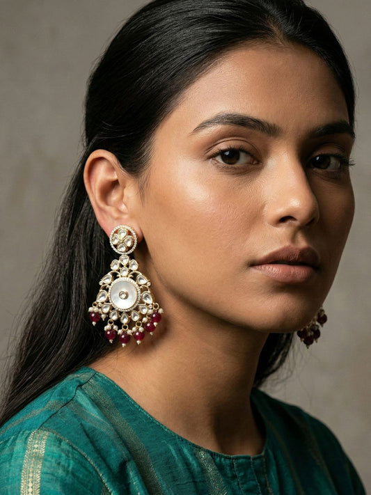 Maroon gold plated Chandbali earrings with a circular mother of pearl centre, teardrop Kundan stones, floral detailing and pearl drops.