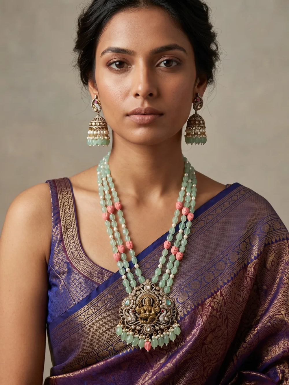 Mint green Lakshmi temple necklace featuring an ornate Goddess pendant, antique-style detailing, layered jade beads and matching jhumka earrings.