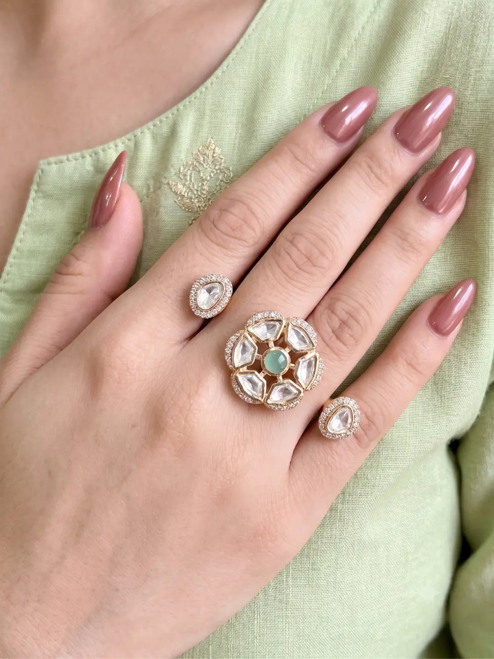 Mint green Polki Kundan double finger ring with two gold-tone bands, floral stonework and sparkling CZ accents for bridal and traditional occasions