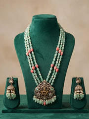 Mint green Lakshmi necklace set with an ornate antique-finish pendant, Kundan and Polki stone detailing, layered beads and matching earrings.