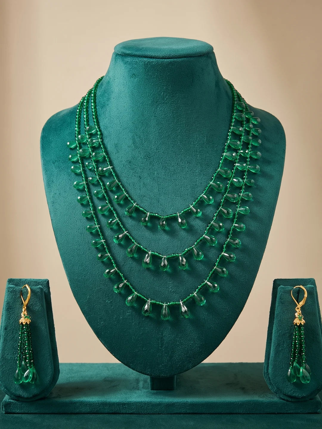 Green layered beaded necklace and drop earrings styled together, showing the fuller look of the strands and teardrop accents around the neckline
