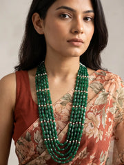 Long multi-strand necklace of polished oval green jade beads with delicate pearl beads, shown as a full layered beaded gemstone necklace