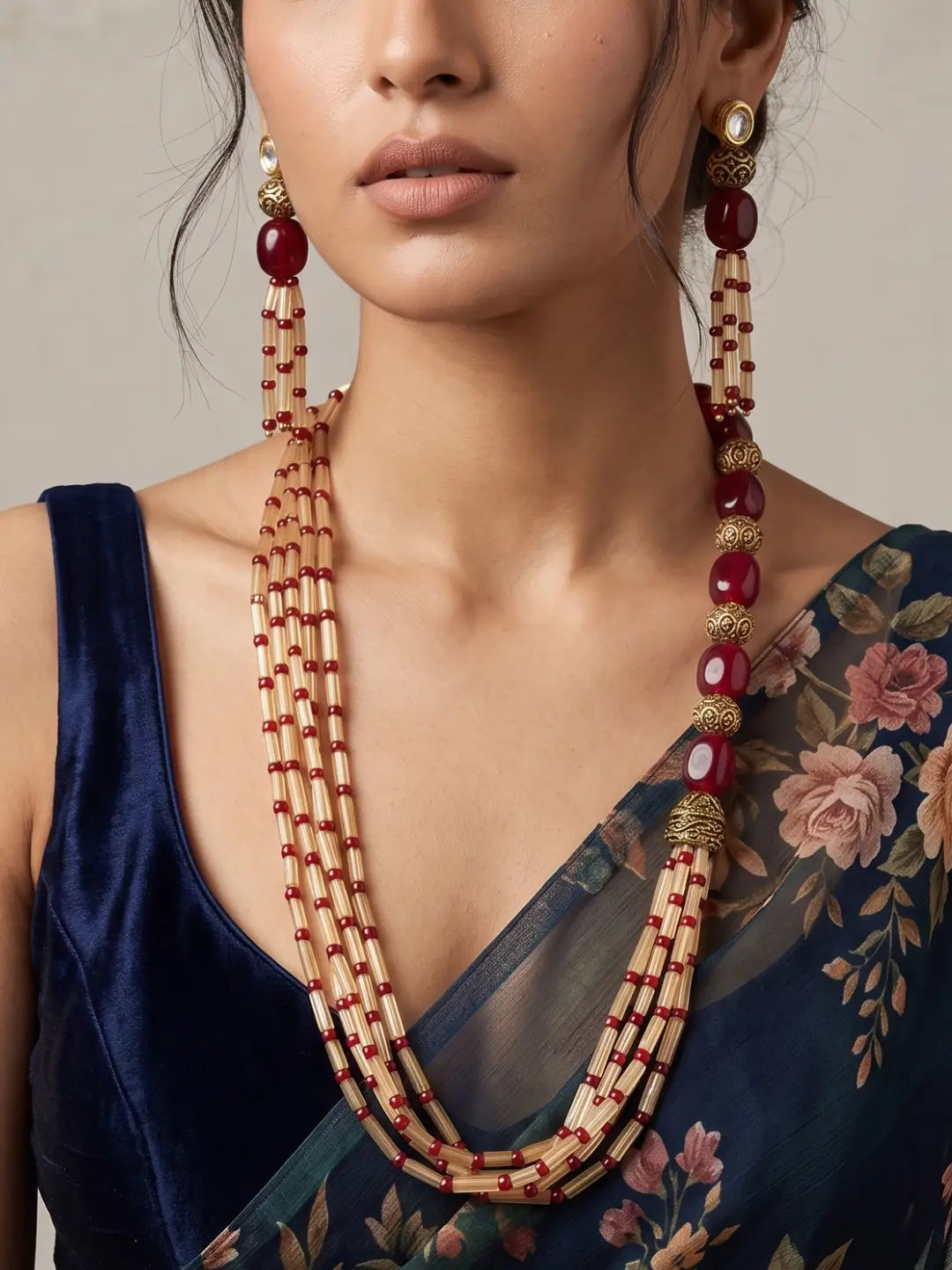 Layered red jade and brown fluorite beaded necklace set with gold-toned detailing, shown with matching earrings that echo the bead accents