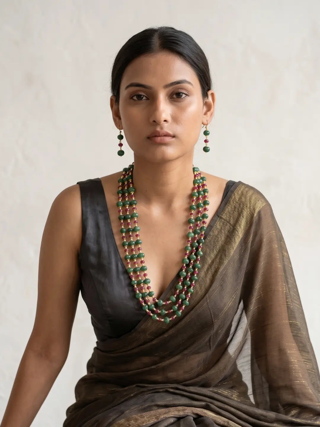 Multi-strand red and green jade necklace featuring watermelon-shaped beads, pearl spacers and gold-toned detailing.