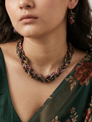 Multi-strand necklace of rectangle-shaped tourmaline beads in black, green, brown and golden yellow with gold-tone spacers, laid out beside earrings