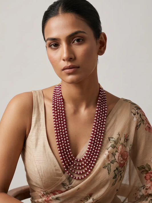 Multi strand ruby red jade and natural freshwater pearl mala with gold-plated details, designed as layered ethnic jewellery for weddings and festivals.