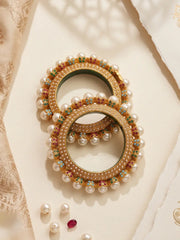 Multicolour Jadau Pearl Pacheli bangles with pink, green and blue stone accents, pearl-style details and a gold-tone base for ethnic looks.