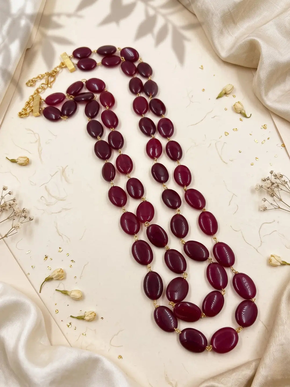 Traditional groom necklace with polished oval red jade beads arranged in two long strands, creating a bold layered look for sherwanis and achkans.