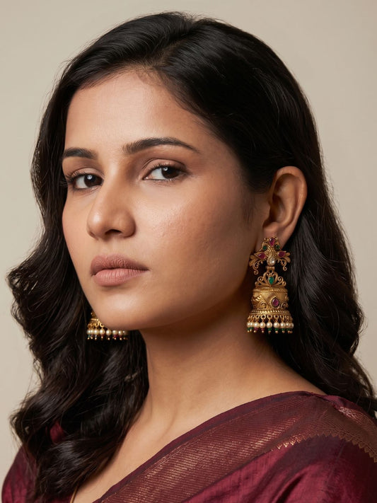 Traditional Peacock Jhumka earrings featuring antique gold detailing, Kundan stonework, colourful accents and pearl tassel drops.