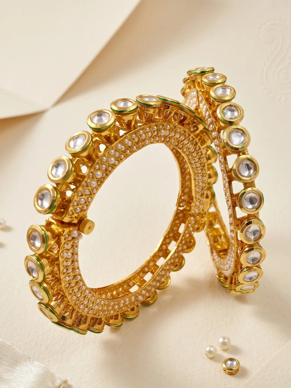 Pearl Kundan Pacheli bangles featuring rows of pearl accents, green Meenakari and Kundan-style stones on a gold-plated base.