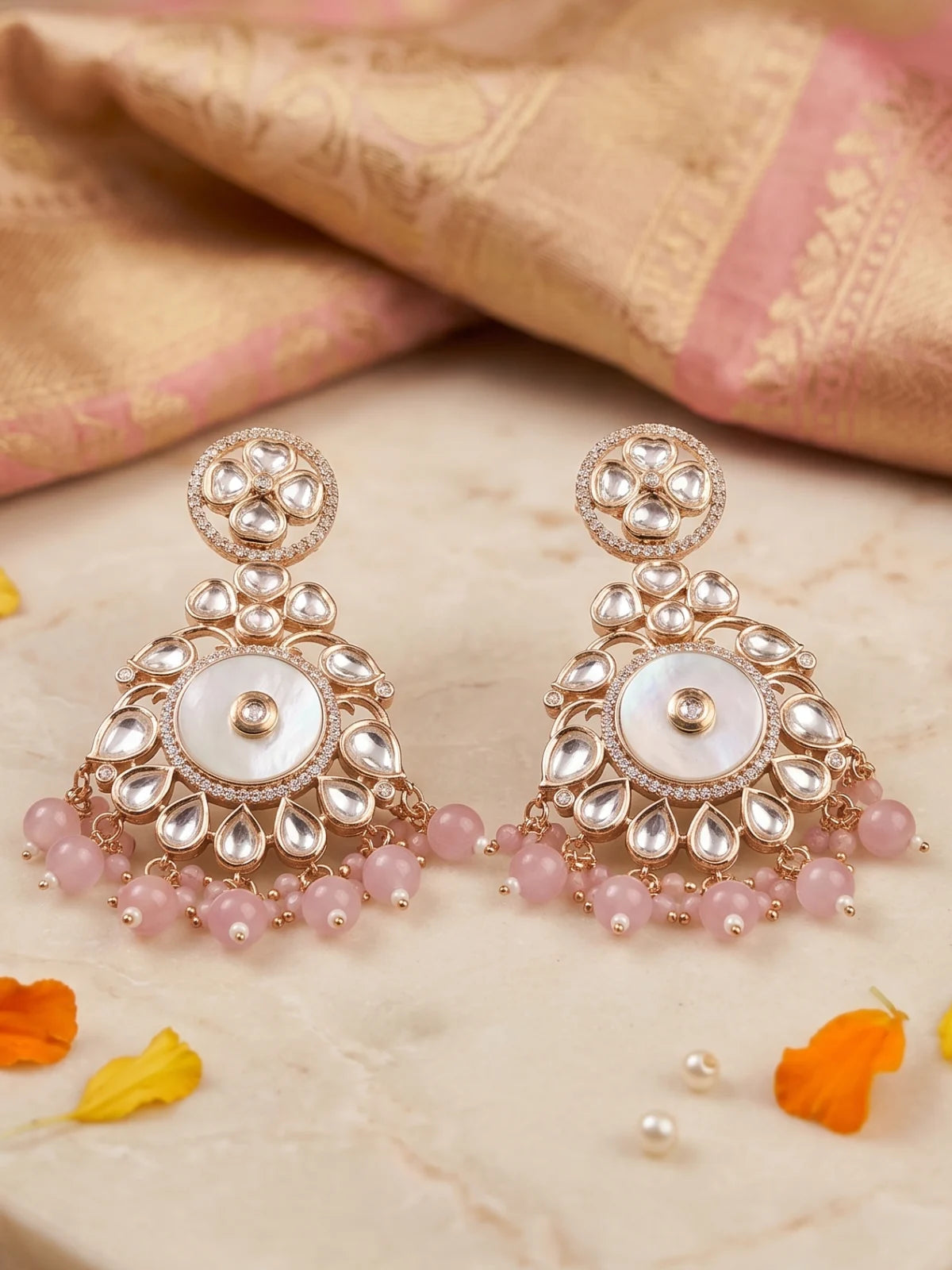 Pink Kundan Chandbali earrings featuring a luminous mother of pearl centre, floral circular stonework and multiple pearl danglers.