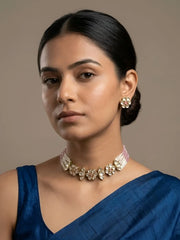 Pink kundan and pearl choker necklace with floral motifs and multi-strand pearl beading displayed together with matching earrings as a set