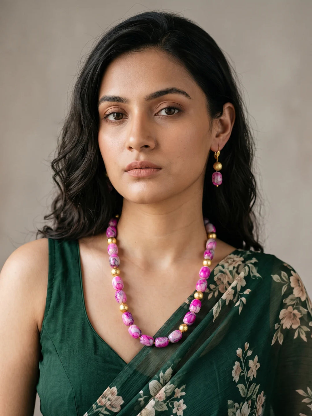 Layered necklace of pink shaded chalcedony cylinder beads with gold-plated round spacer beads, laid out in a curve beside a pair of matching drop earrings