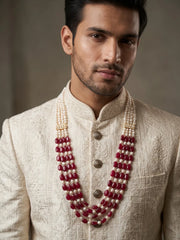- Multi-strand groom necklace combining deep red oval jade beads with natural freshwater pearls and decorative gold-tone kundan accents for sherwanis.