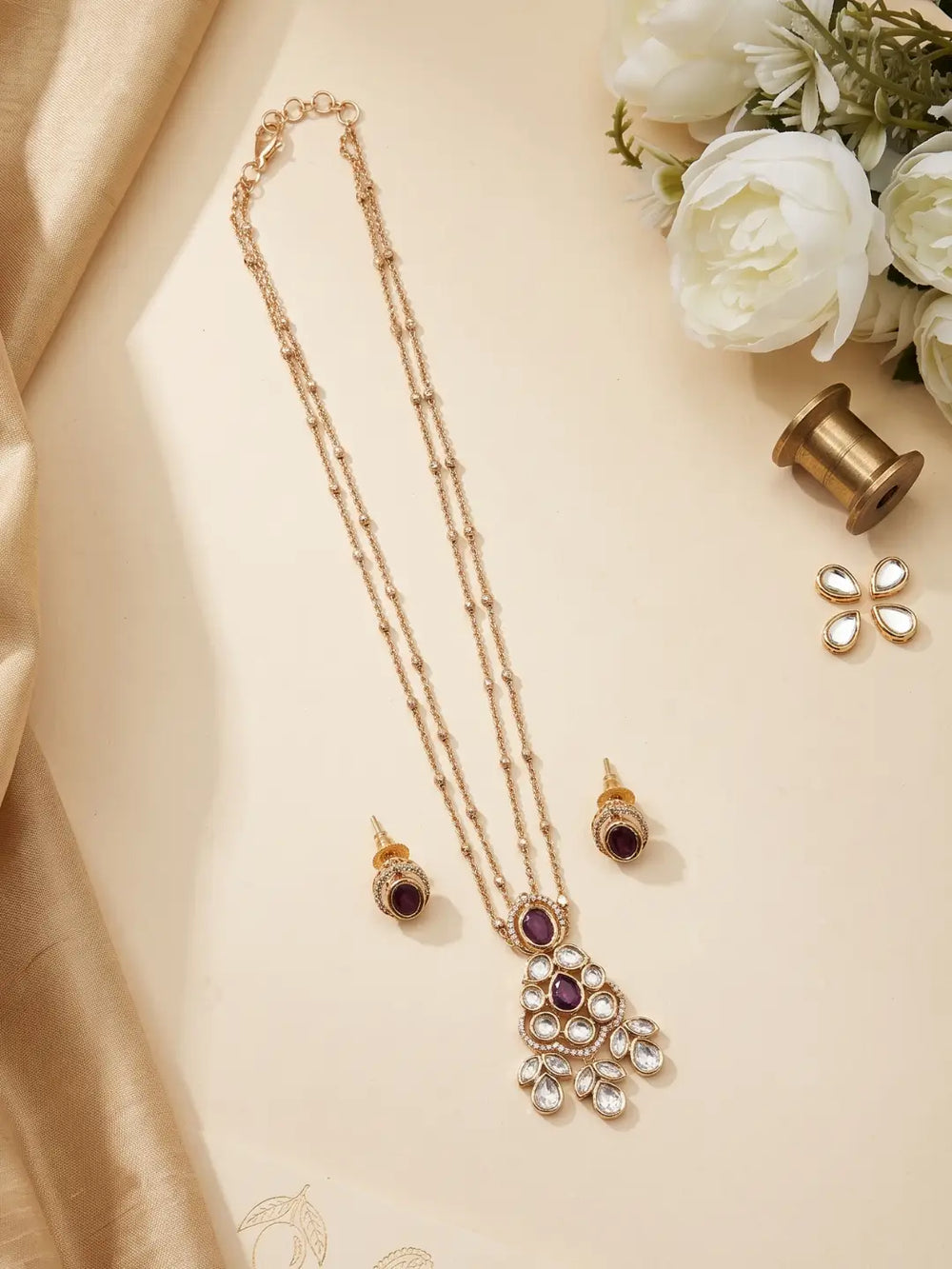 Red teardrop pendant framed with Polki and CZ stones, accompanied by matching stud earrings in a coordinated gold plated design.