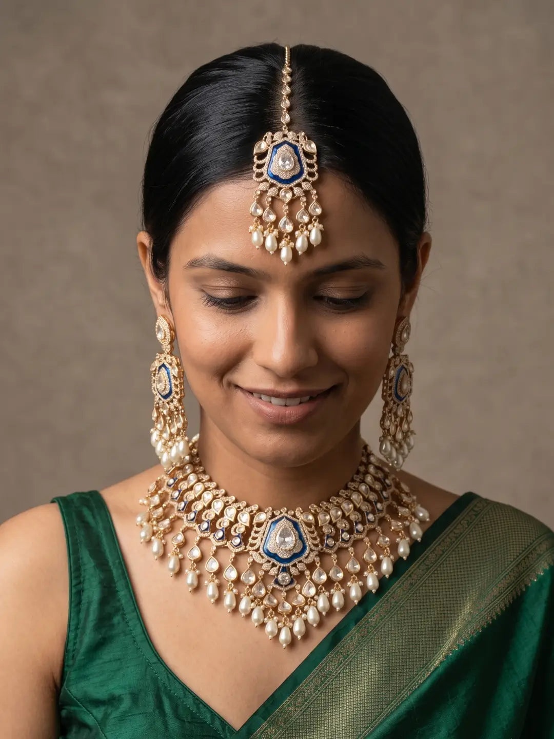 Royal blue Kundan Polki bridal jewellery set featuring a gold-plated necklace, statement earrings, matching maang tikka, CZ stones and cascading pearl drops.