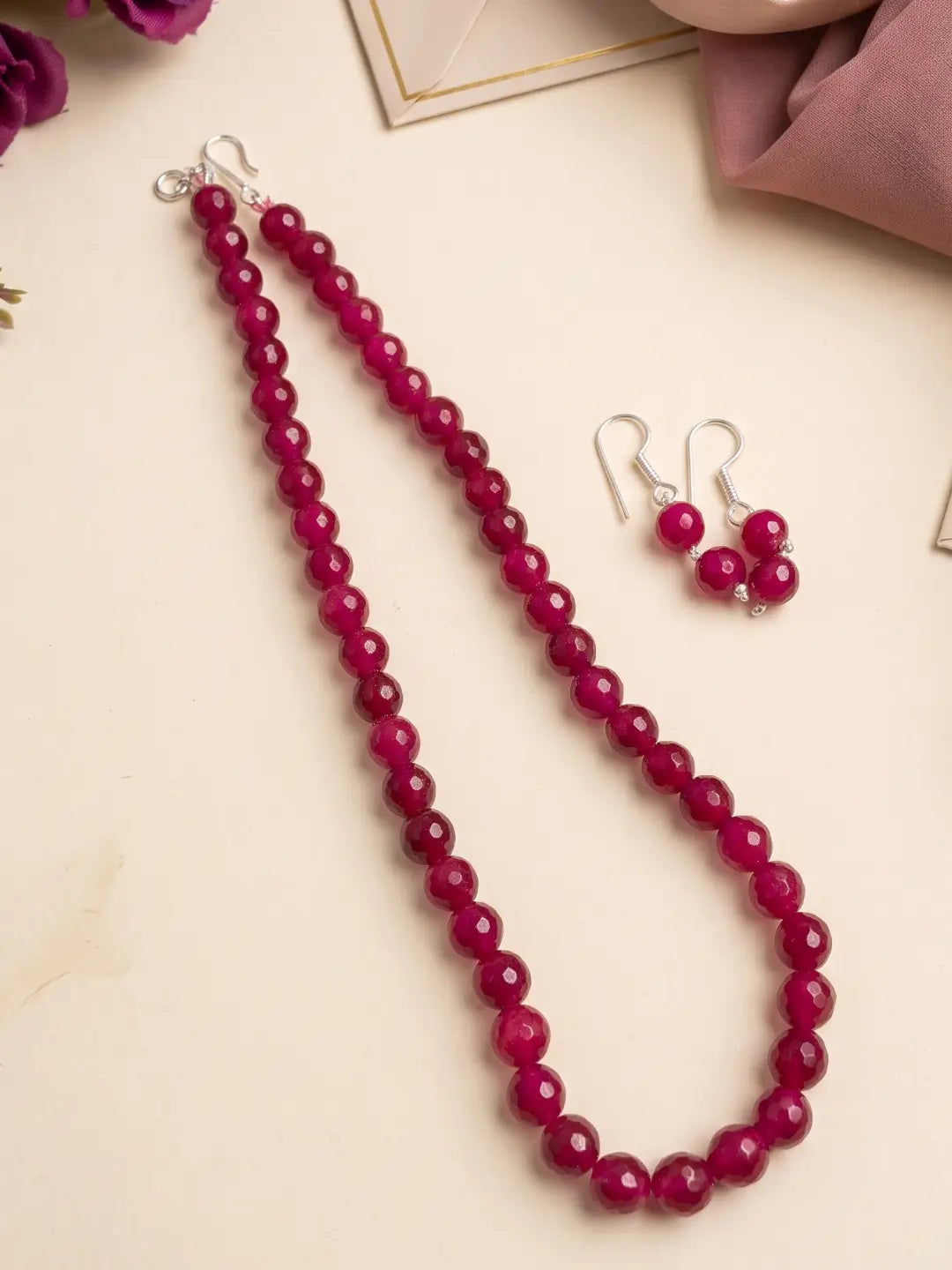 Single-strand ruby pink faceted round jade bead mala necklace shown with matching drop earrings and silver-tone accents