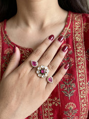 Ruby pink dual-finger Polki ring with a floral centre, matching pear-shaped motifs, CZ stone detailing and a gold-plated finish.