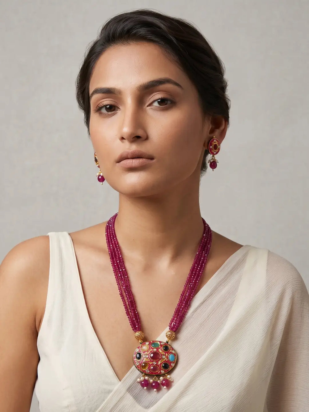 Ruby pink layered bead necklace with a decorative multicolour Navratna pendant and matching stud earrings.