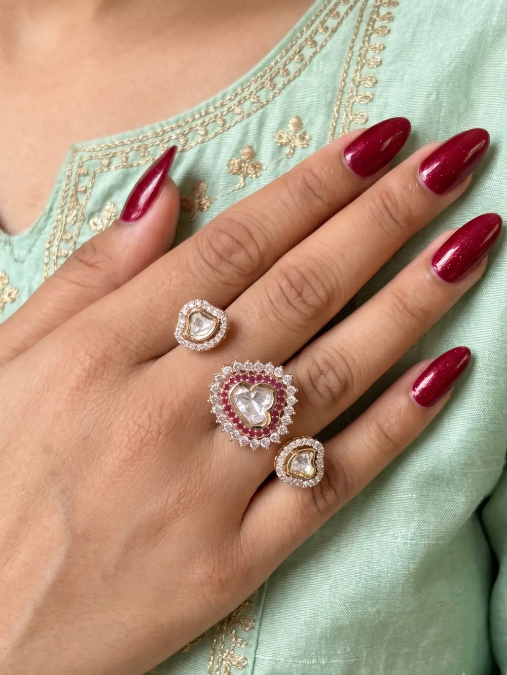 Ruby pink Polki dual finger ring with two connected gold-tone bands, Kundan stonework, ruby accents and sparkling CZ details for bridal styling