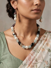 Black and grey beaded necklace set with creamy white shell pearls and pale blue topaz chips, shown with matching drop earrings