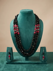 Silver-plated hook and eye closure at the back of a multi strand black and red beaded necklace, shown beside the beaded strands