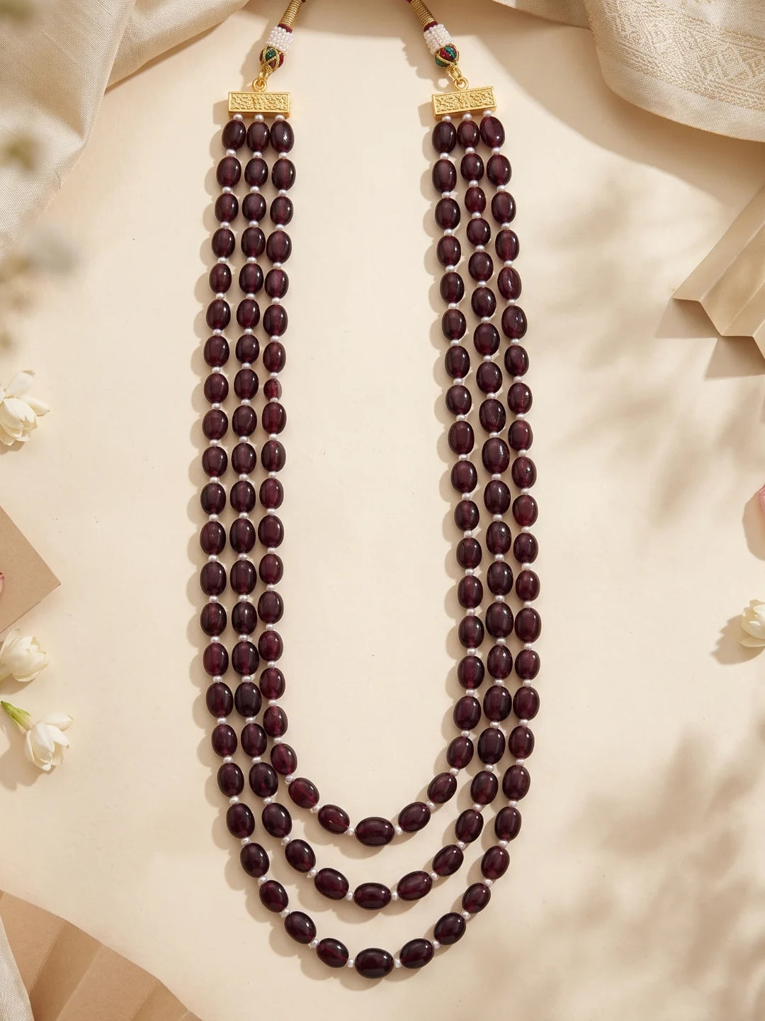 Traditional three-layer dulha haar featuring burgundy natural garnet beads and freshwater pearls, designed to complement an embroidered wedding sherwani.