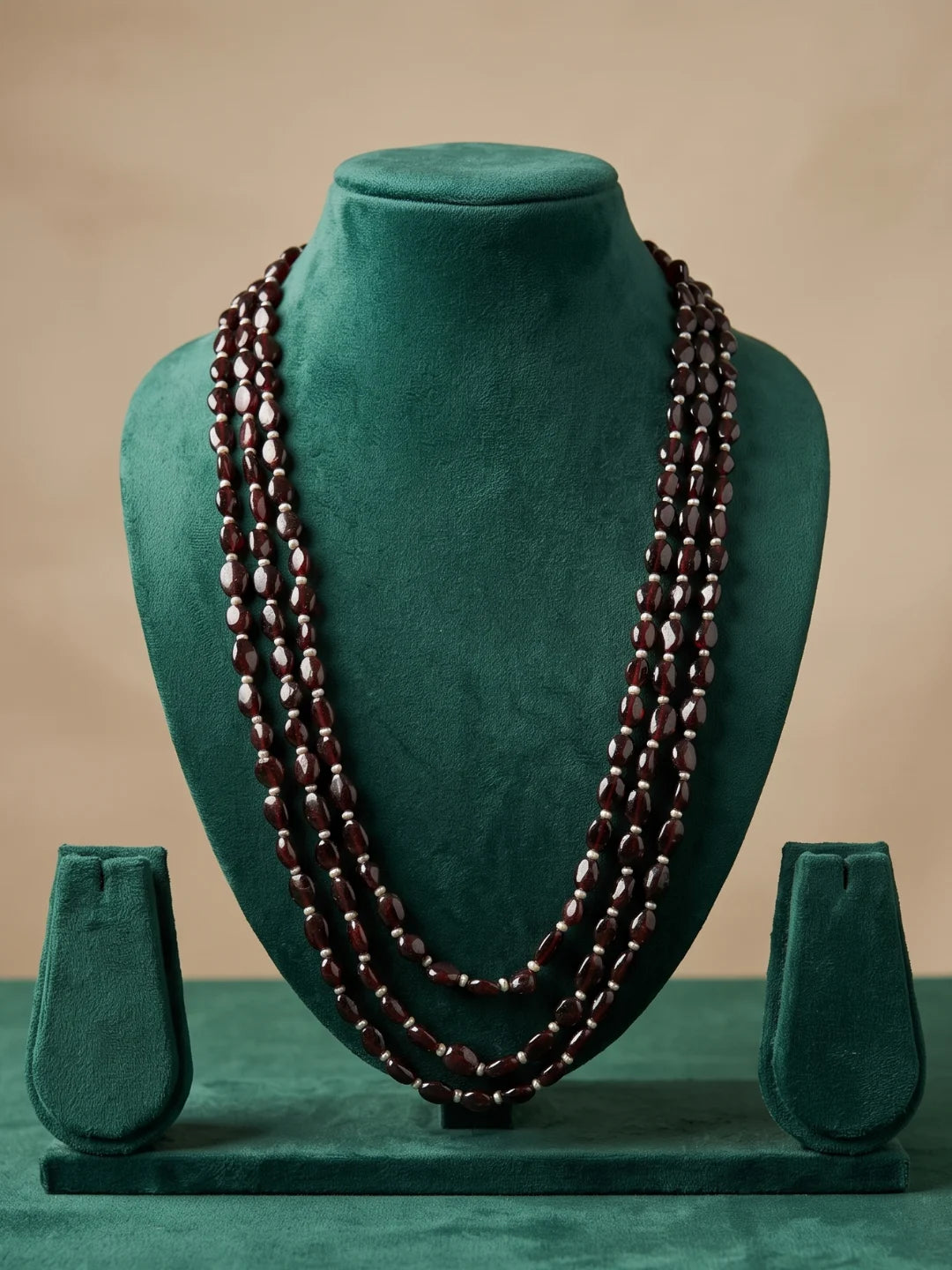 Three-layer dulha necklace combining polished oval garnet beads with freshwater pearls for a traditional groom's sherwani ensemble.