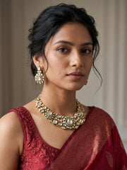Gold-plated green Polki-style necklace with a prominent central motif, symmetrical stonework and coordinated drop earrings.