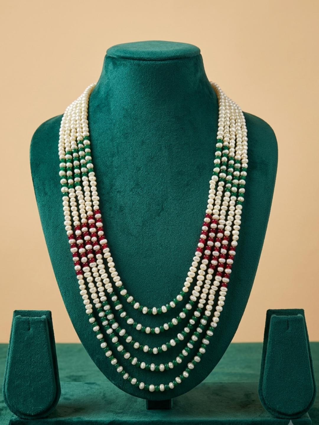 Cascading white freshwater pearl necklace with red and green jade bead accents, designed to complement sarees and traditional ethnic outfits.