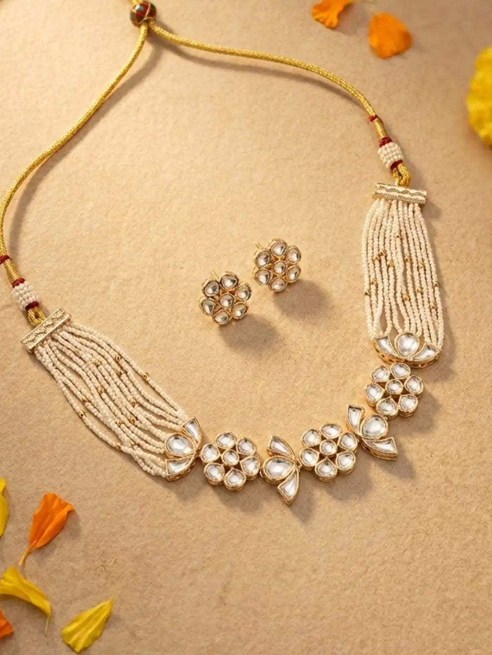 Pair of white floral kundan earrings with pearl detailing, 2.5 inches long and 1 inch wide, matching the pearl choker necklace